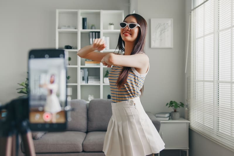 a girl dancing in front of a phone camera for social media