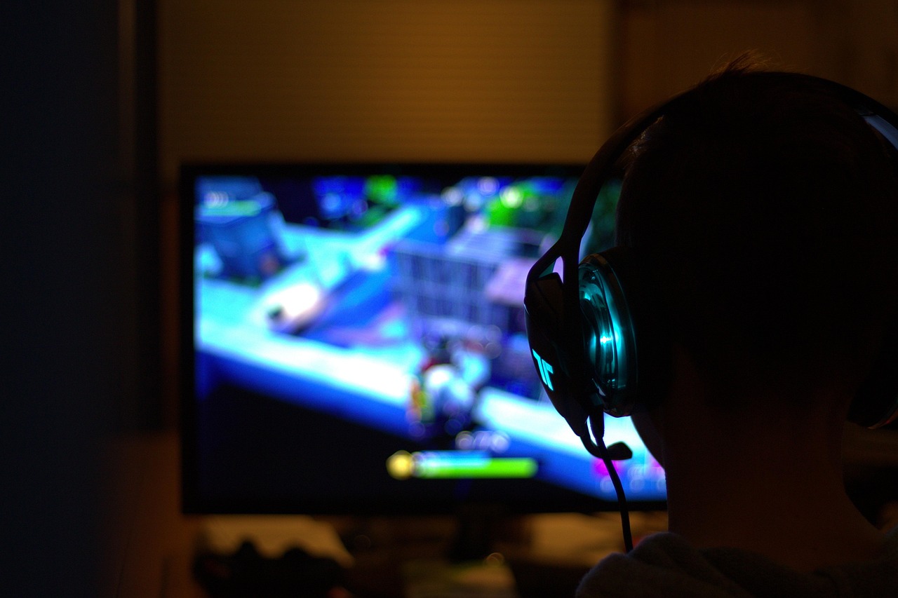 A gamer with headphones watches a video on a game streaming platform. 