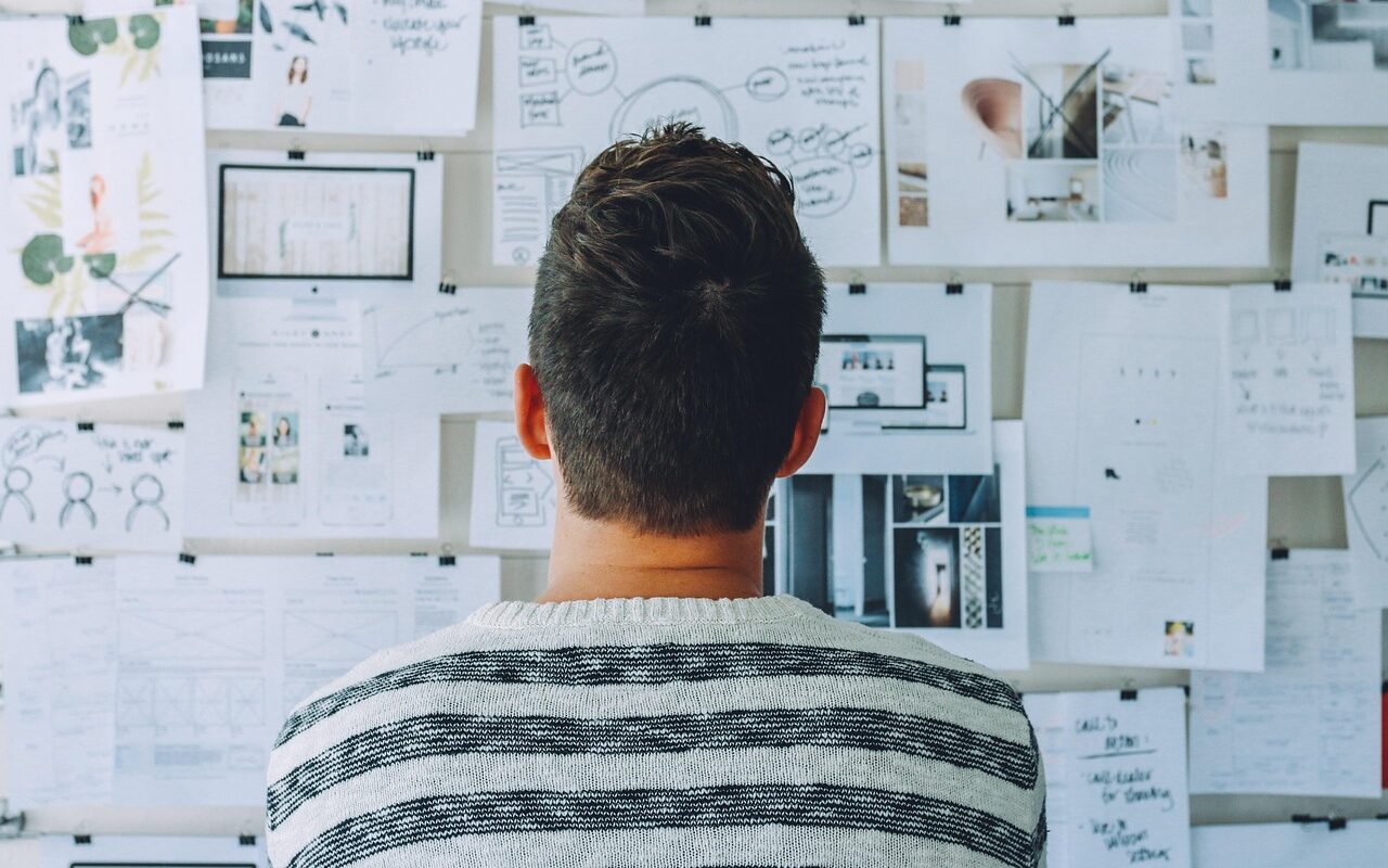 The startup owner looks at the strategy plan on the wall.