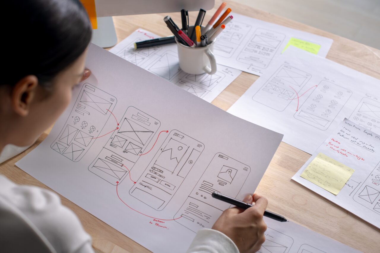 person looking at a website wireframes drawn on paper
