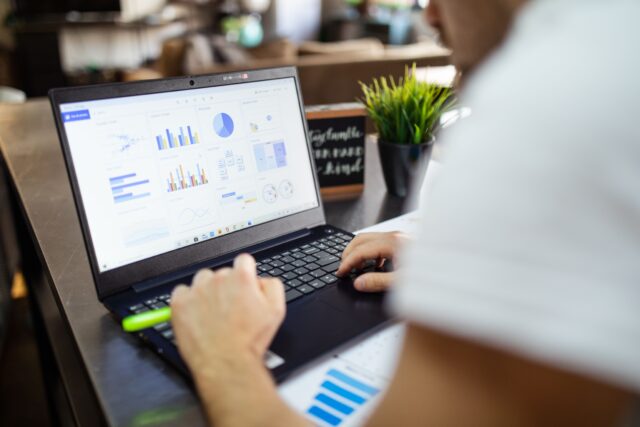 Professional analyzing business performance metrics and customer retention rates on a laptop screen