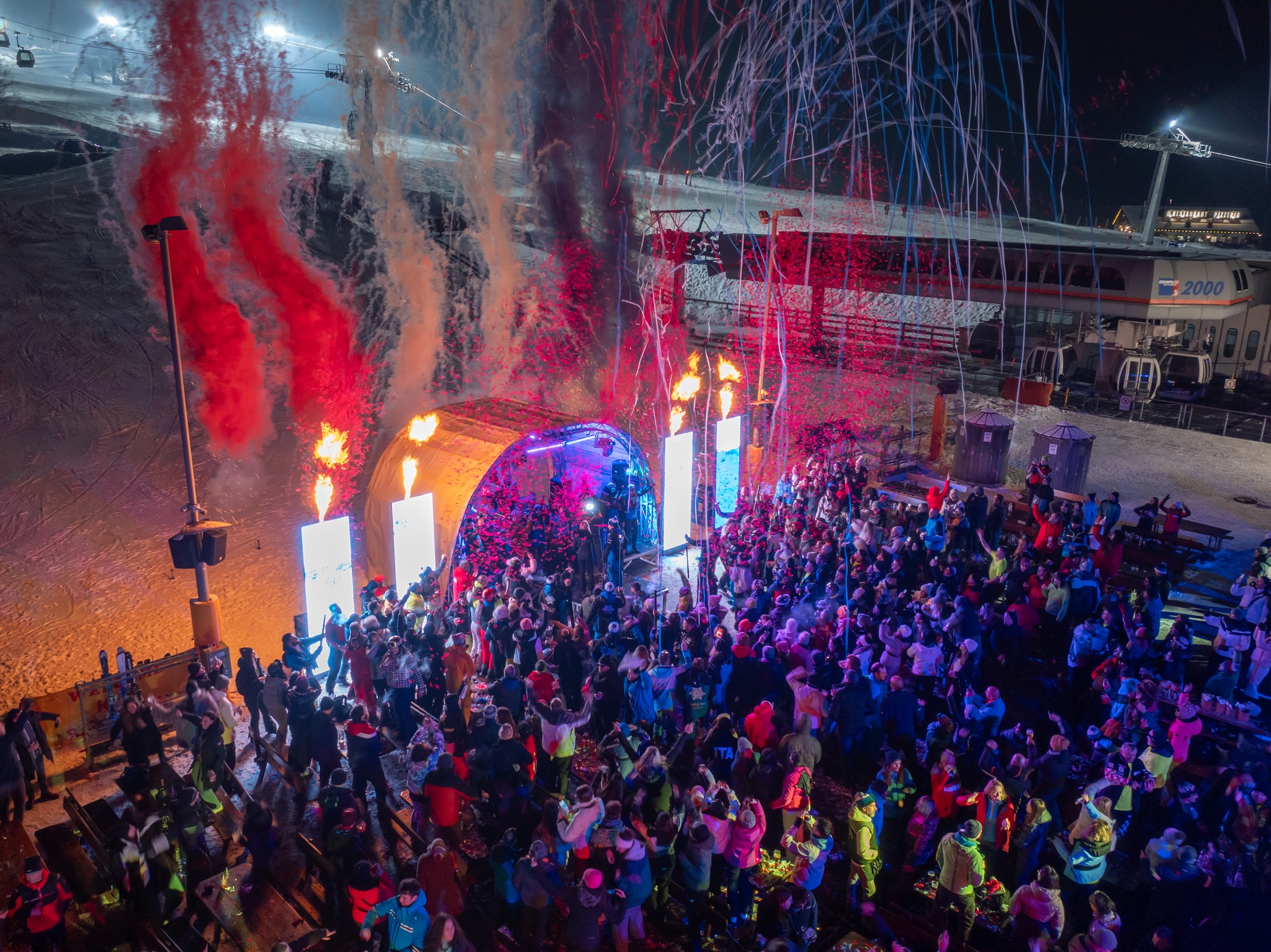 Large crowd enjoying an outdoor HULJS SKI party at night.