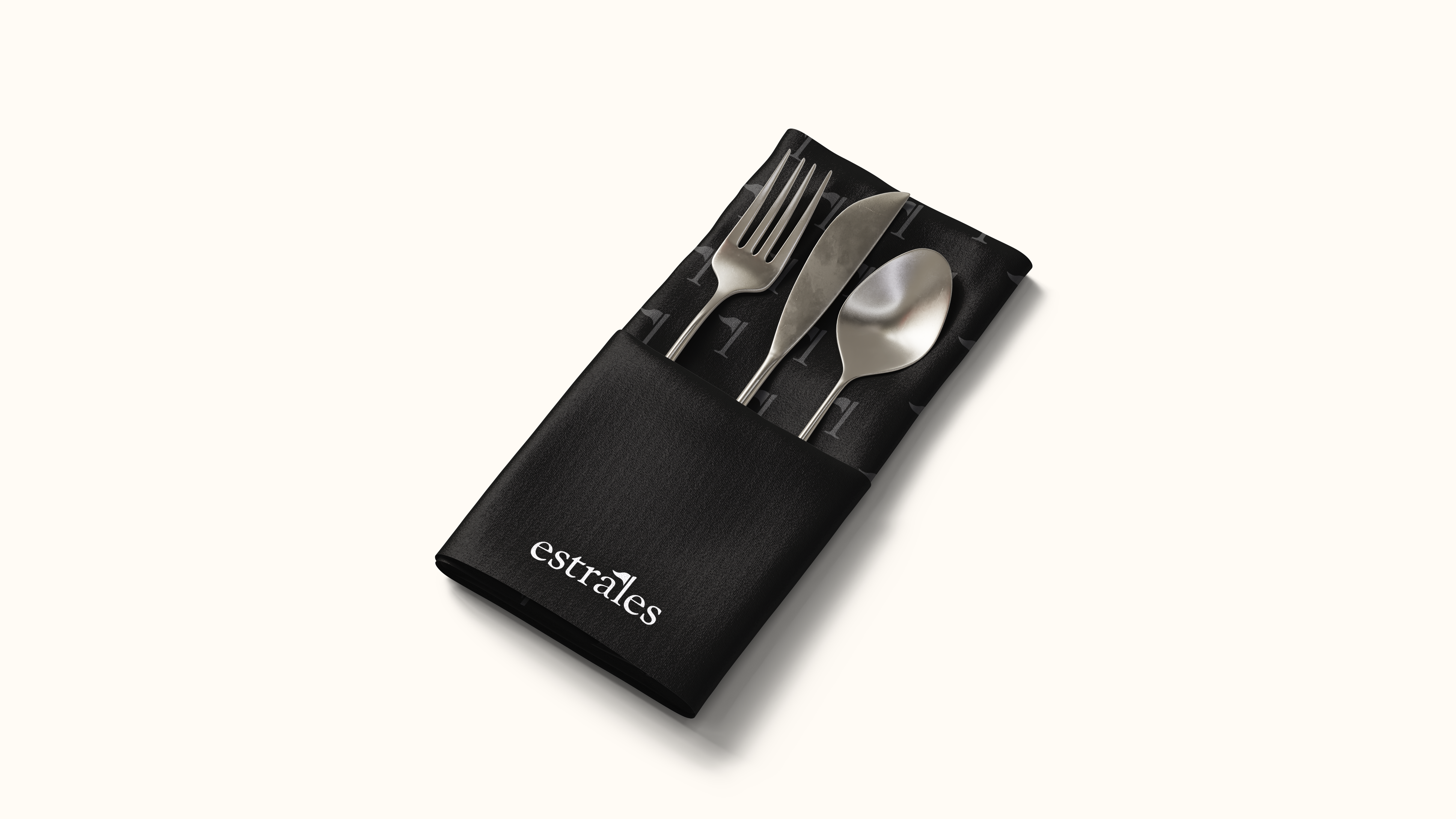 Black Estrales branded napkin with cutlery, featuring the logo and graphic pattern.